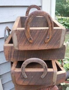 three wooden boxes stacked on top of each other in front of a house with metal handles