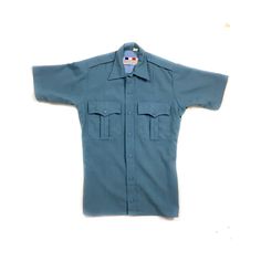 "70s/80s vintage short-sleeve unisex button-down shirt.  Air force blue with two large chest pockets and buttoned épaulettes.  Thick and durable quality fabric.  Three pleats at the back and two at the front for a sharp fit.  Formally an ambulance driver uniform shirt (badges removed).  The rest of the UNISEX VINTAGE COLLECTION by Radical Silk here: https://www.etsy.com/shop/radicalsilk/?section_id=27136906 ESTIMATED ERA: 1970s or 1980s BRAND: Flying Cross FABRIC: 65% Dacron polyester, 35% rayon Uniform Shirts, Air Force Blue, Vintage Shorts, Ambulance, Military Fashion, Quality Clothing, Vintage Collection, Air Force, Quality Fabric