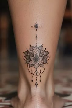 a woman's foot with a flower tattoo on the side of her leg,