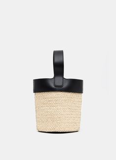 Bolso bucket de Loewe en rafia y piel para llevarlo cruzado, al hombro o en la mano. Con cierre magnético, medallón con anagrama grabado que permite ajustarlo hasta una longitud de 15 cm, bandolera ajustable y extraíble con una máxima de 119 cm. Hecho en España. Medidas: 19,5 x 16 x 16 cm. Material: 100% rafia / piel. Leather Bucket Bag With Detachable Strap In Natural Color, Natural Leather Bucket Bag With Detachable Strap, Modern Woven Leather Bucket Bag, Chic Leather Bucket Straw Bag, Beige Woven Leather Bucket Bag, Black Bucket Straw Bag, Leather Bucket Bag With Adjustable Strap For Beach, Modern Beige Woven Bucket Bag, Natural Leather Bucket Bag