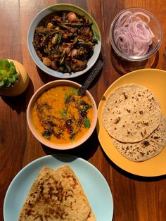 several plates of food on a table with bowls and utensils next to each other