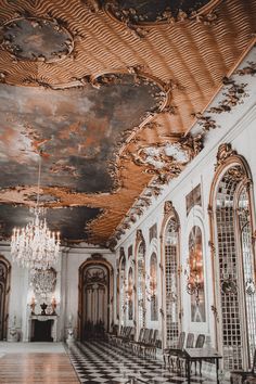 an ornately decorated room with chandeliers and chairs on the floor, in front of a painted ceiling