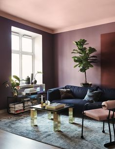 two different rooms, one with purple walls and the other with blue furniture in it