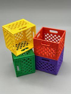 three different colored baskets sitting next to each other on a gray surface with no one in the photo