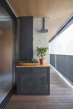 a balcony with a planter on top of it and an air conditioner in the background