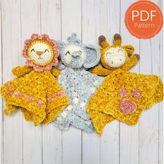 three crocheted stuffed animals laying next to each other on a white wooden surface