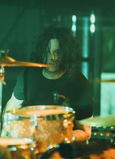 a man that is sitting in front of some drums