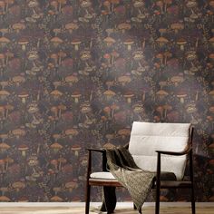 a chair sitting on top of a wooden floor next to a wallpaper covered in mushrooms