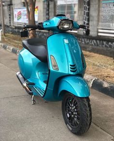 a blue scooter is parked on the sidewalk