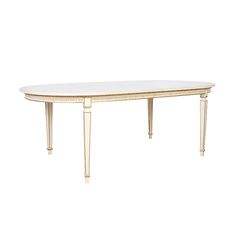 a white table with gold trimmings on the legs and a oval shaped top