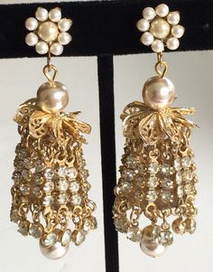 Here is a rare and absolutely dazzling pair of vintage earrings by designer Miriam Haskell. These earrings are exquisitely fashioned in an ultra glamorous chandelier style with multiple glittering strands of sparkling clear rhinestones with accents of bigger glimmering rhinestone drops at each swaying end. The shimmering strands are suspended on gold tone links from ornate crowns of glinting gold tone filigree and lustrous faux baroque pearls.The earring tops are made in a lovely floral motif... Victorian Dangle Chandelier Earrings For Parties, Victorian Chandelier Dangle Earrings For Party, Victorian Style Party Chandelier Earrings, Ornate Chandelier Earrings For Evening, Victorian Chandelier Drop Earrings For Evening, Glamorous Evening Jeweled Clip-on Earrings, Victorian Chandelier Earrings For Evening, Glamorous Jeweled Clip-on Earrings For Evening, Victorian Chandelier Drop Earrings For Evenings