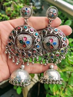 Add charm and charisma to your beautiful personality with these exquisitely handcrafted Afghani earrings jhumkas made with high quality German Silver. The intricate design and the glass enamel work renders these earrings a very unique and classy look. Pair them up with any formal or casual attire and gather compliments all the way!Weight  36 gmLength 4 inches Width 1.8" inches Multicolor Metal Chandbali Earrings, Multicolor Temple Jewelry Earrings For Festival, Multicolor Oxidized Temple Jewelry Earrings, Traditional Multicolor Oxidized Earrings, Festive Multicolor Oxidized Earrings, Multicolor Metal Earrings For Festivals, Bohemian Oxidized Chandelier Earrings For Festive Occasions, Bohemian Oxidized Finish Chandelier Earrings For Festive Occasions, Bohemian Metal Jhumkas