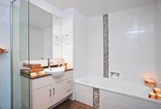 a bathroom with a sink, mirror and bathtub