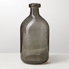 a gray glass bottle sitting on top of a table