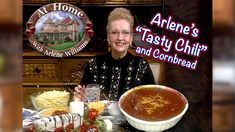 an older woman sitting at a table with a bowl of soup in front of her