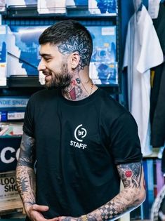 a man with tattoos on his face and chest standing in front of a store display