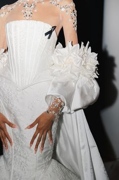 a woman in a white wedding dress with flowers on her arm