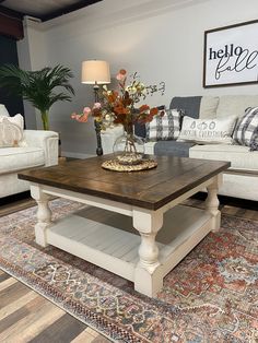 a living room with couches, tables and rugs on the carpeted floor