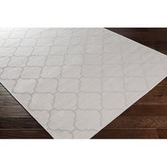 a white rug on top of a wooden floor