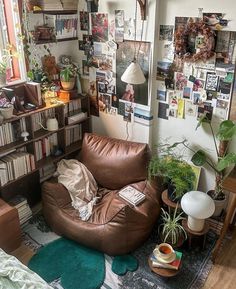 a living room filled with furniture and lots of books on the shelves next to a window