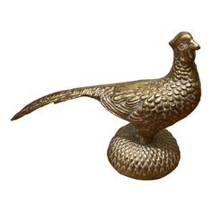 a golden bird statue sitting on top of a metal base