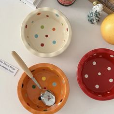 three bowls and spoons on a table