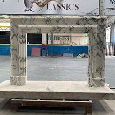 an antique marble fireplace surround in a warehouse