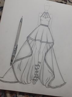 a drawing of a dress on paper with a pen