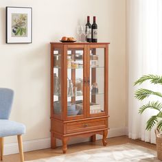 a wooden cabinet with glass doors and drawers in a living room next to a blue chair