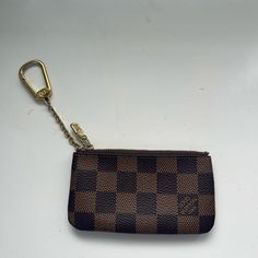 a brown and black checkered purse with a key chain