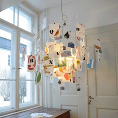 a chandelier hanging from the ceiling in front of a window filled with magnets