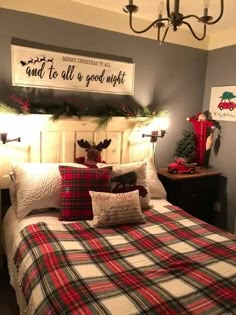 a bedroom decorated for christmas with plaid bedding and pillows, lights on the headboard