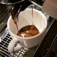 coffee being poured into a white cup