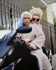 a man and woman are sitting on a motorcycle