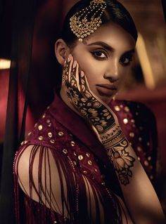 a woman with henna on her hand and arm is posing for a photo shoot