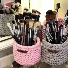 two baskets filled with makeup brushes on top of a counter