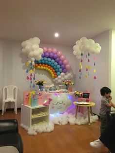 a child's birthday party with balloons, clouds and rainbows on the wall