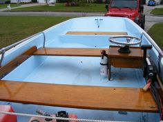 the inside of a blue boat parked in front of a red truck