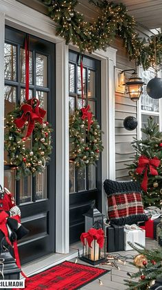 christmas decorations on the front porch of a house with wreaths and presents hanging from the door