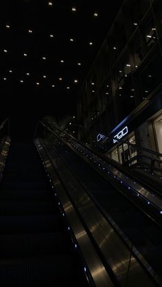 an escalator at night with lights on it