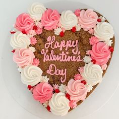 a heart - shaped cake with pink and white frosting on it that says happy valentine's day