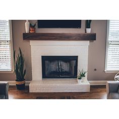 a living room with two couches and a television mounted on the wall above a fireplace