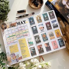 an open planner sitting on top of a table next to some flowers and other items