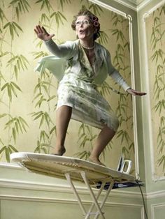 a woman standing on top of a ironing board