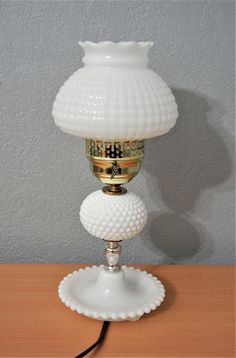 a white lamp sitting on top of a wooden table