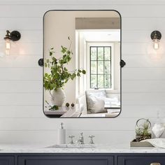 a large mirror hanging on the wall above a sink