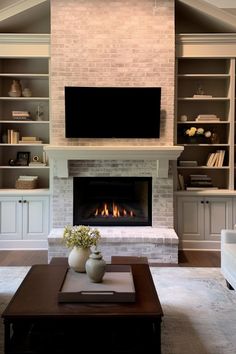 a living room with a fireplace and built in bookshelves