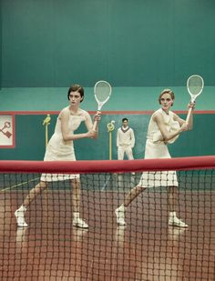 four tennis players are on the court with their racquets in each hand