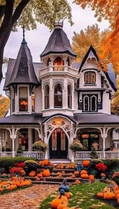 a large white house with lots of pumpkins on the ground