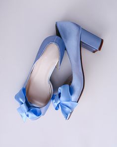 a pair of blue high heeled shoes with a bow on the front and side